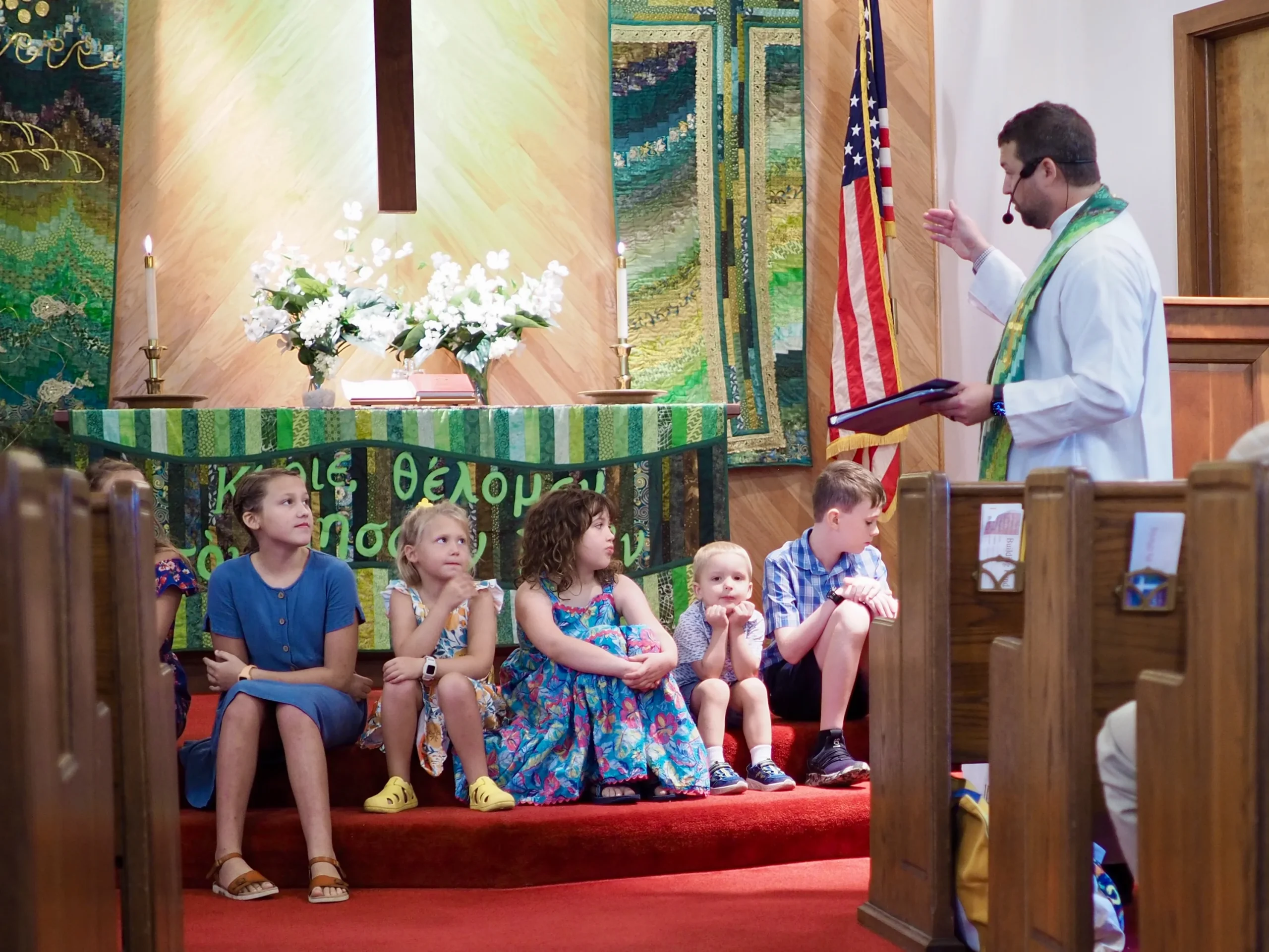 Children seated together at the front of the church during a worship service